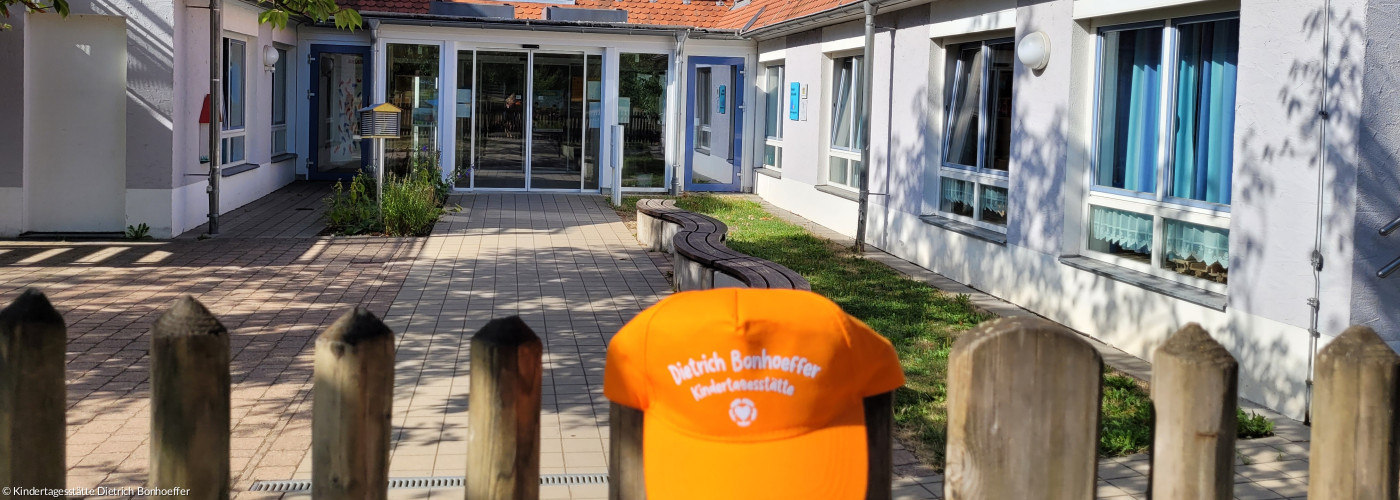 Orangene Cape auf dem Gartenzaun vor dem Eingang der Kindertagesstätte