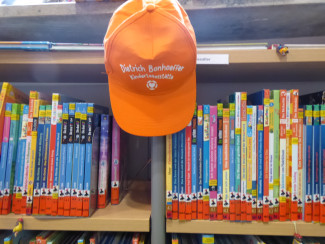 Kindergarten Cap hängt am Bücherregal